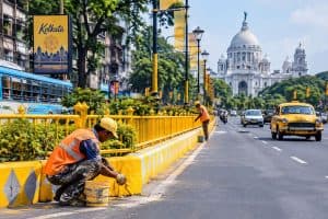 Kolkata Durga Puja Preparation: दुर्गा पूजा और पीएम मोदी के आगमन से पहले कोलकाता में सड़क मरम्मत, रंगाई और रोशनी का काम तेज है। कई इलाकों में नीले-सफेद की जगह बासंती रंग नजर आ रहा है।